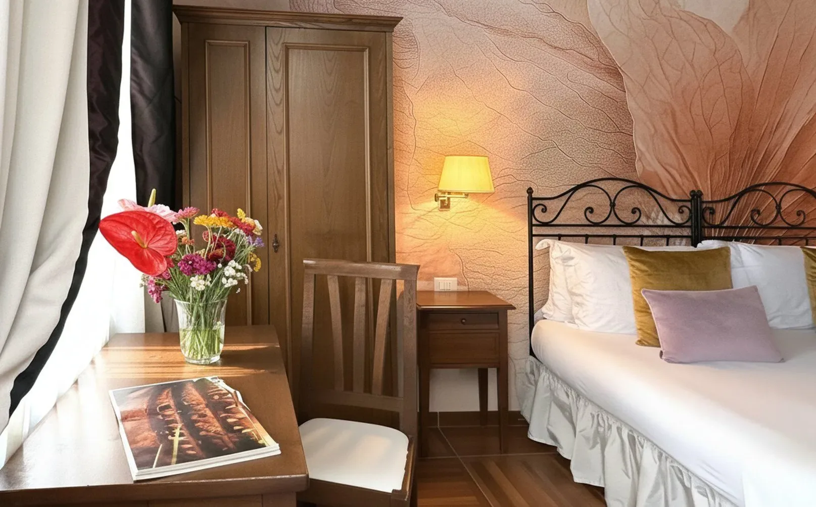 Dormitorio con cama, muebles de madera, flores y papel pintado estampado.