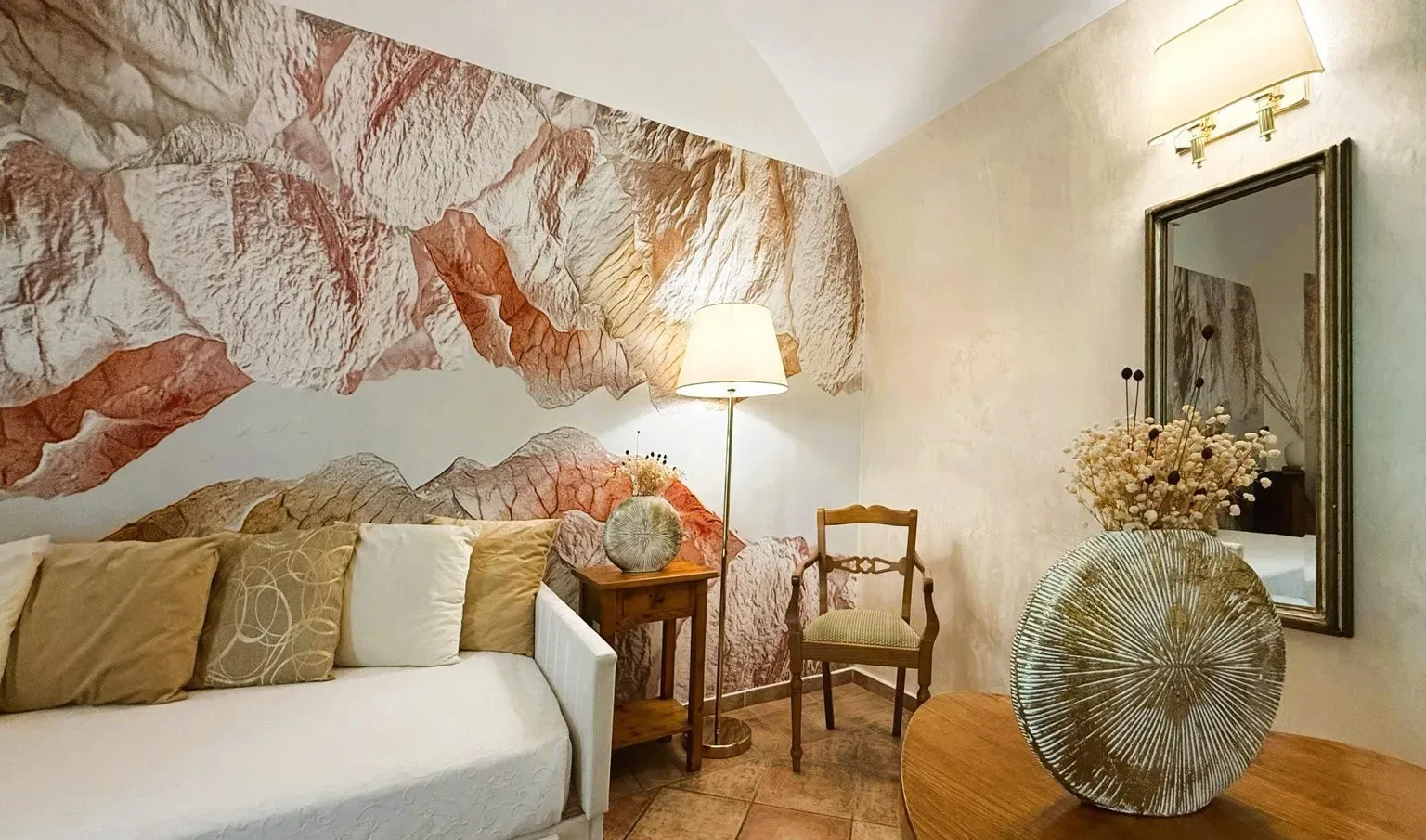 Sala de estar con sofá, mesa auxiliar, silla y jarrón grande.