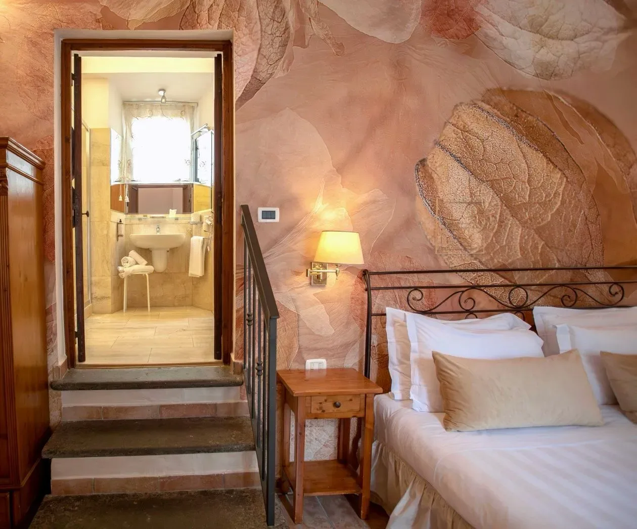 Dormitorio con cama, mesita de noche y puerta al baño.