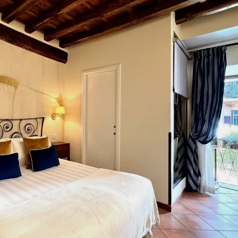 Dormitorio con cama, mesita de noche y balcón.