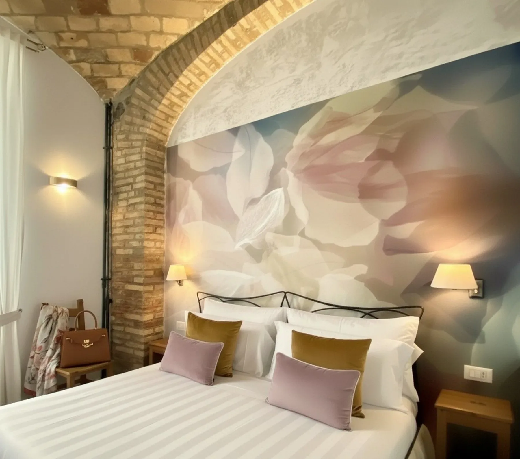 Dormitorio con mural floral, arco de ladrillo visto y cama.