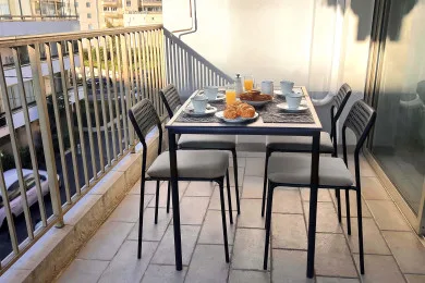 A balcony dining area with a table set for a meal.