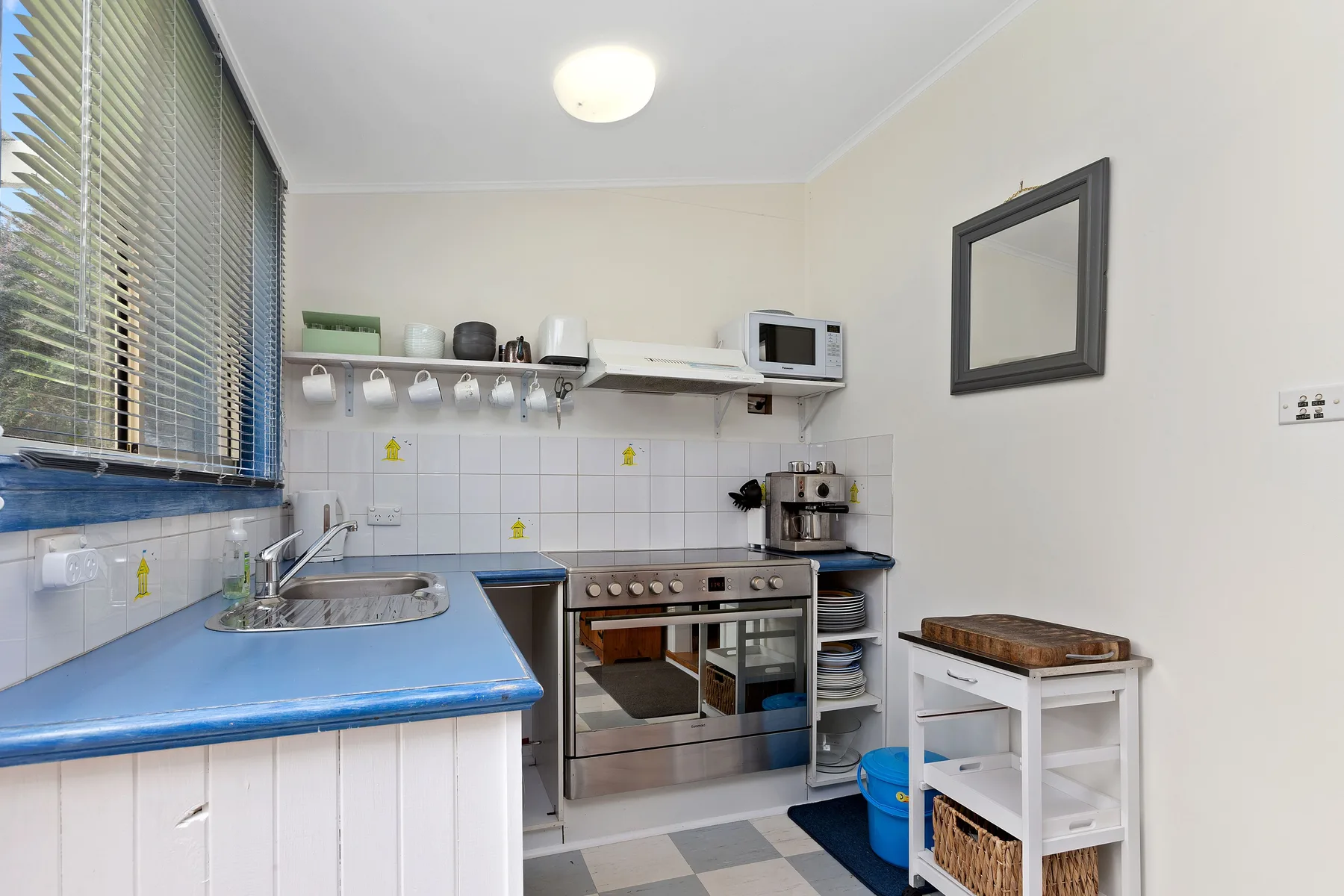 Una cocina compacta con encimeras azules, un fregadero y una estufa.