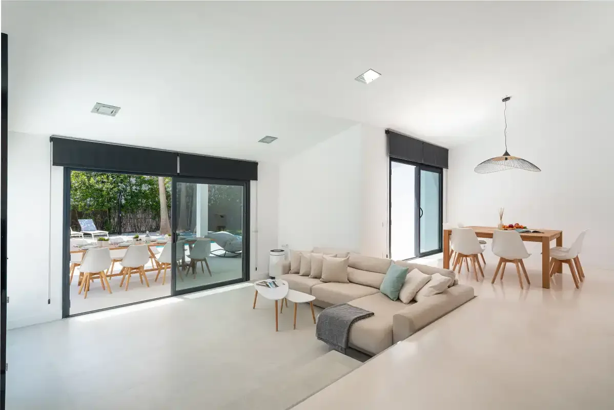 A bright living and dining area opens onto a patio through sliding glass doors.