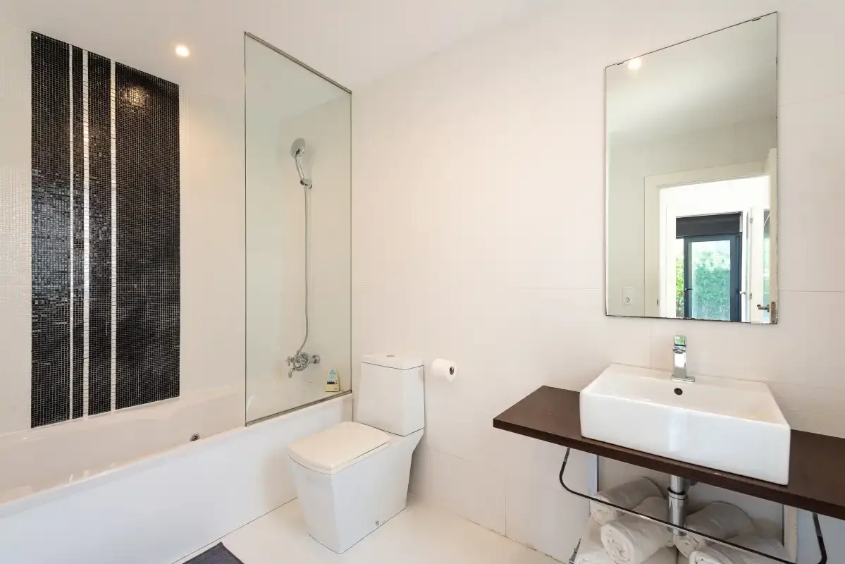 A bright bathroom with a bathtub, shower, toilet, and sink.