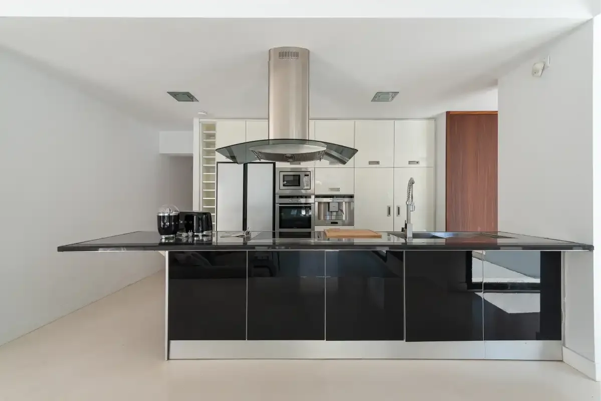 A modern kitchen with dark cabinets and a wide central island.
