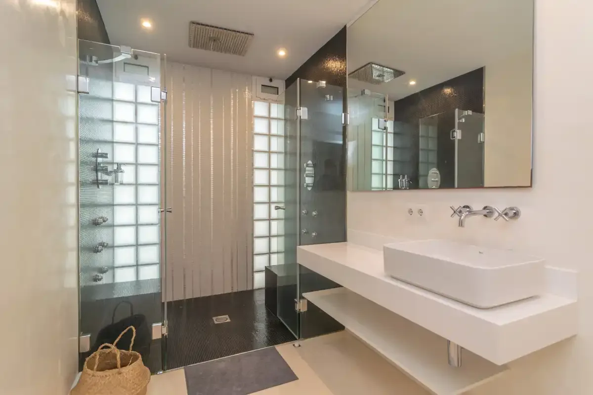A modern bathroom with a glass shower and a wide vanity.