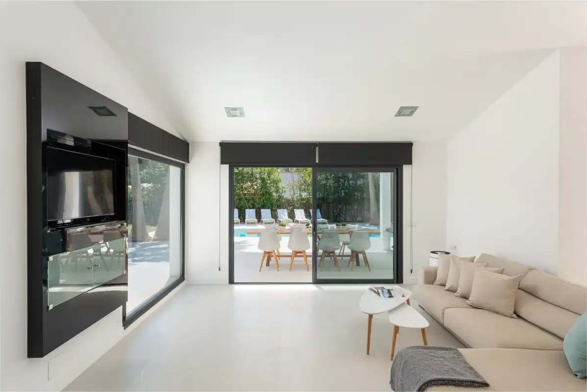 A bright living room with seating and sliding glass doors opening onto a patio.