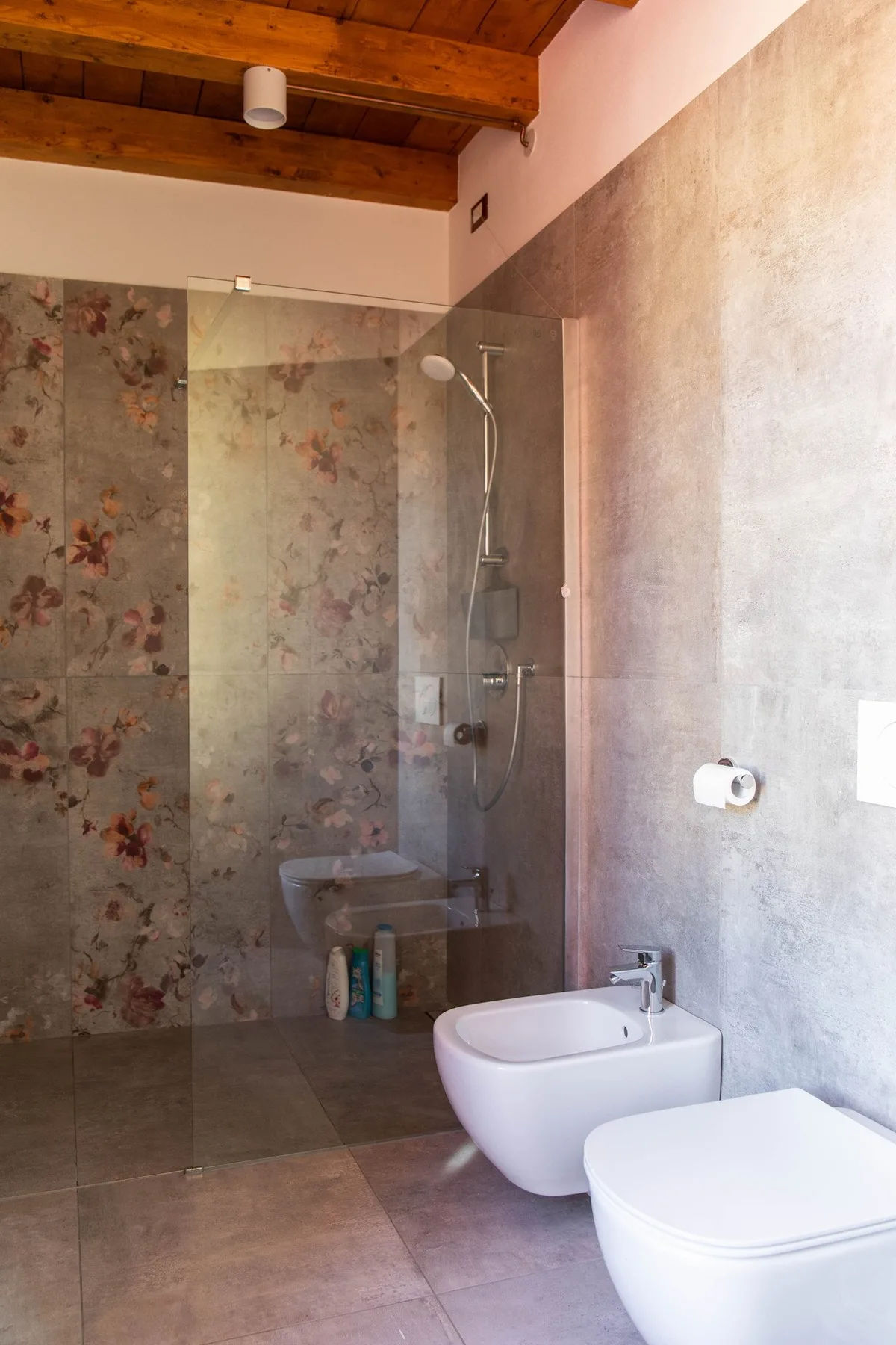 Un baño con ducha de vidrio, lavabo e inodoro.