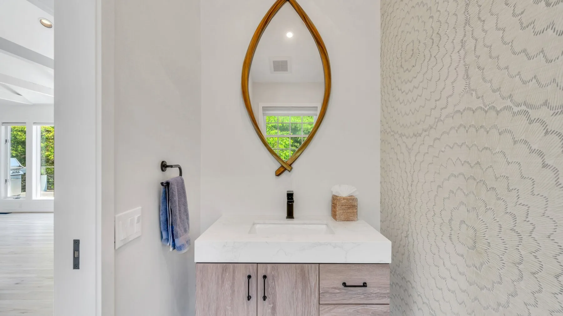 Un lavabo de baño con un espejo decorativo.