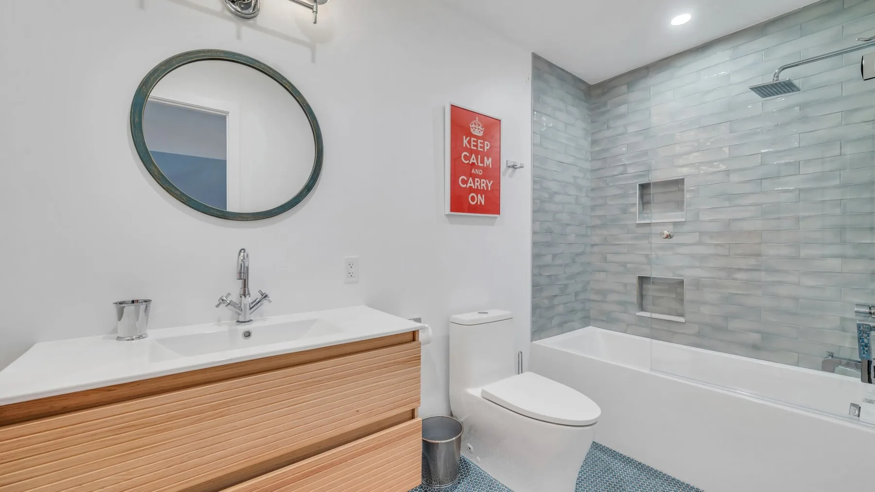 Un baño luminoso con un tocador amplio y una zona de ducha con azulejos.