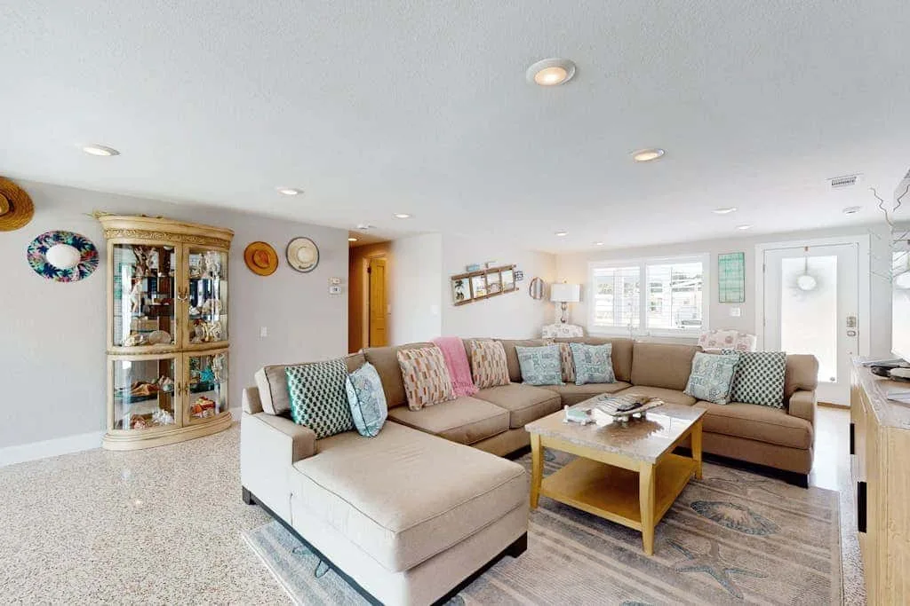 A bright living room features an L-shaped seating area and a coffee table.