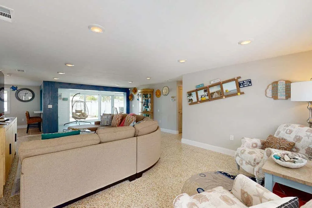 A living room with seating arranged around a bright window.