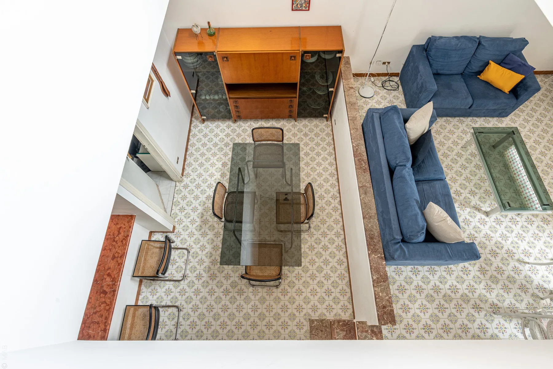 A living room with blue seating arranged around a glass coffee table.