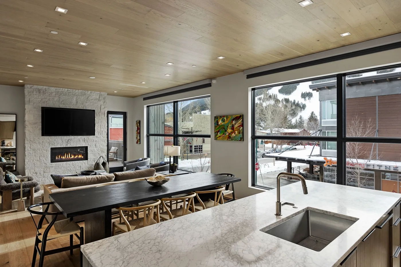 An open-plan kitchen and living area with large windows and a broad island.