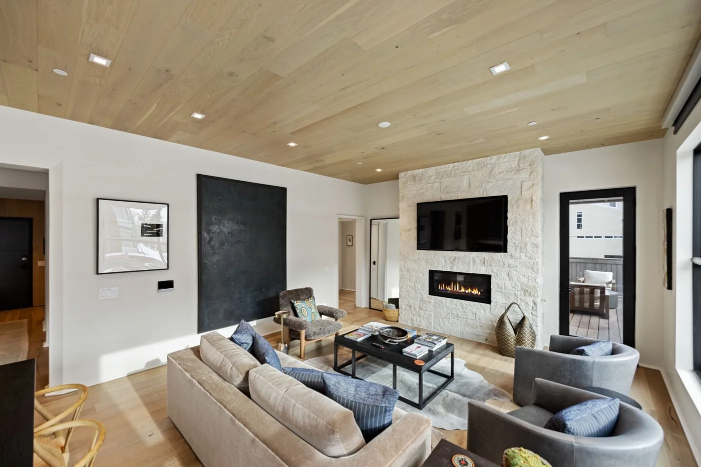 A modern living room with seating arranged around a coffee table and fireplace.