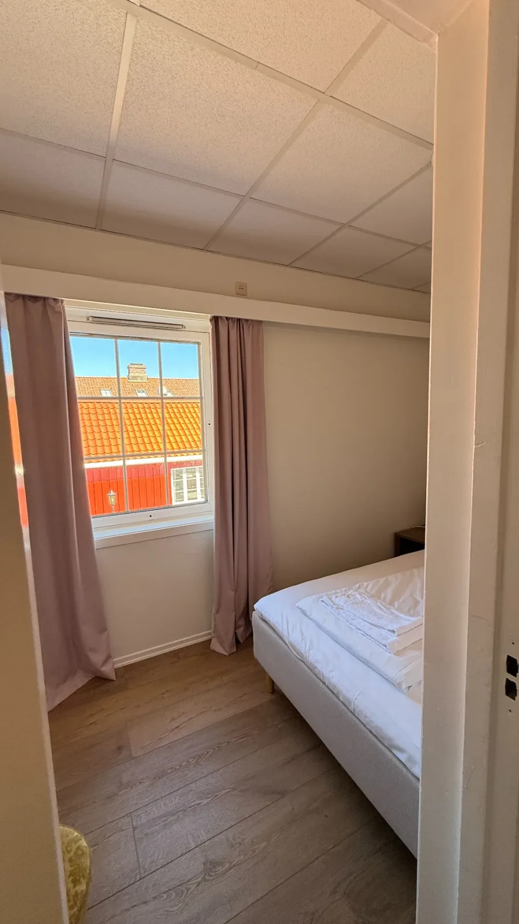 Family room with single bed and view toward the wooden houses