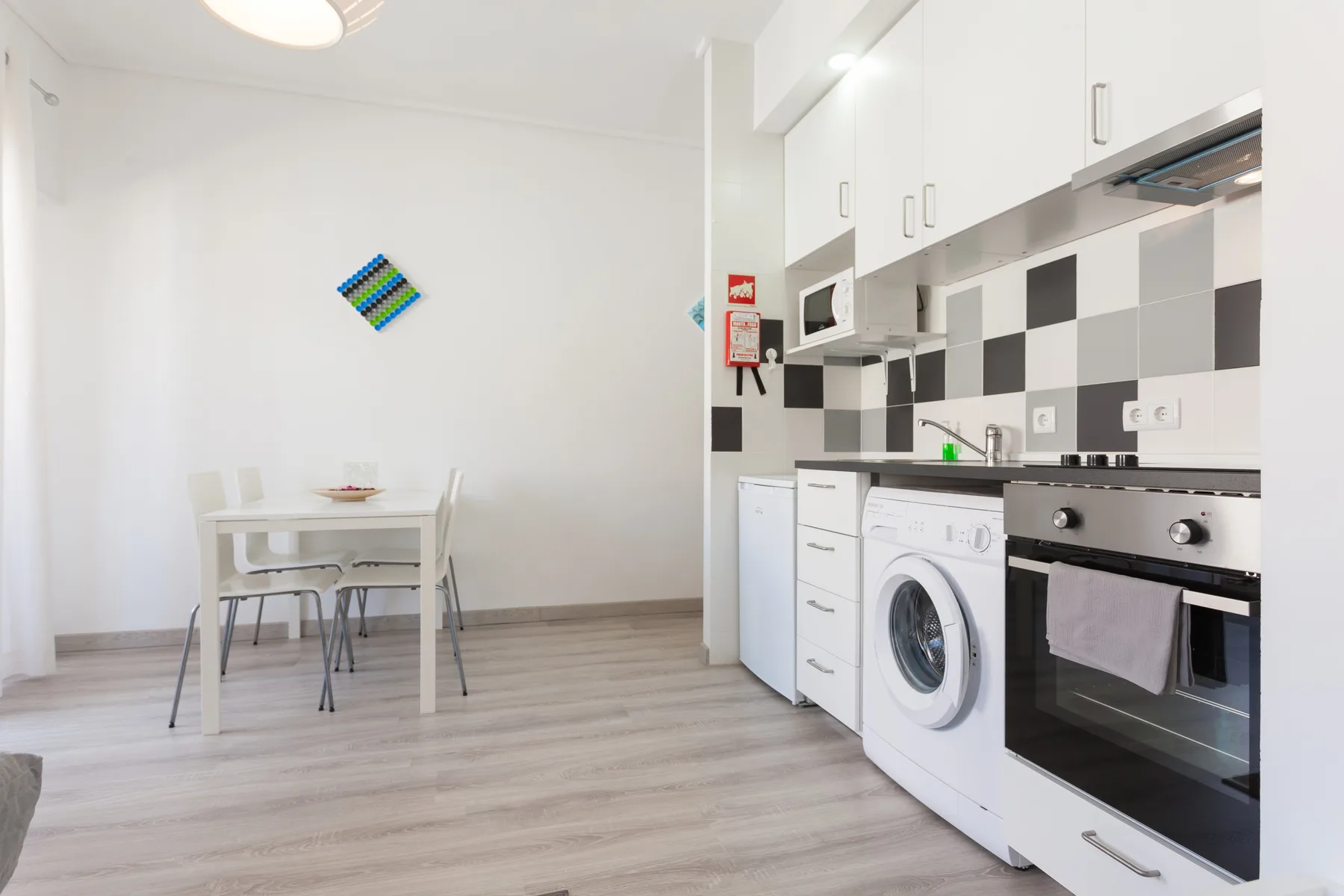 Una cocina luminosa con zona de comedor y una mesa junto a la encimera.