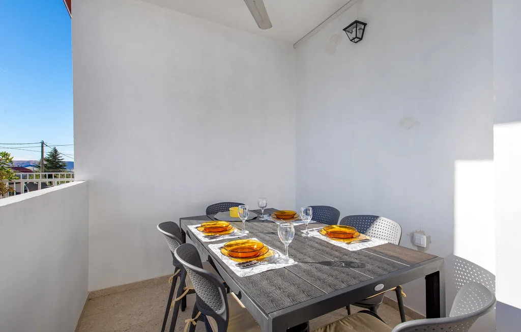 A covered outdoor dining area with a table set for a meal.