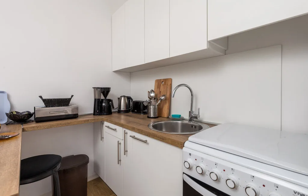 A compact kitchen with a countertop, sink, and washing machine.