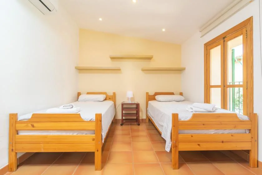 A bedroom with two single beds and a small bedside table.