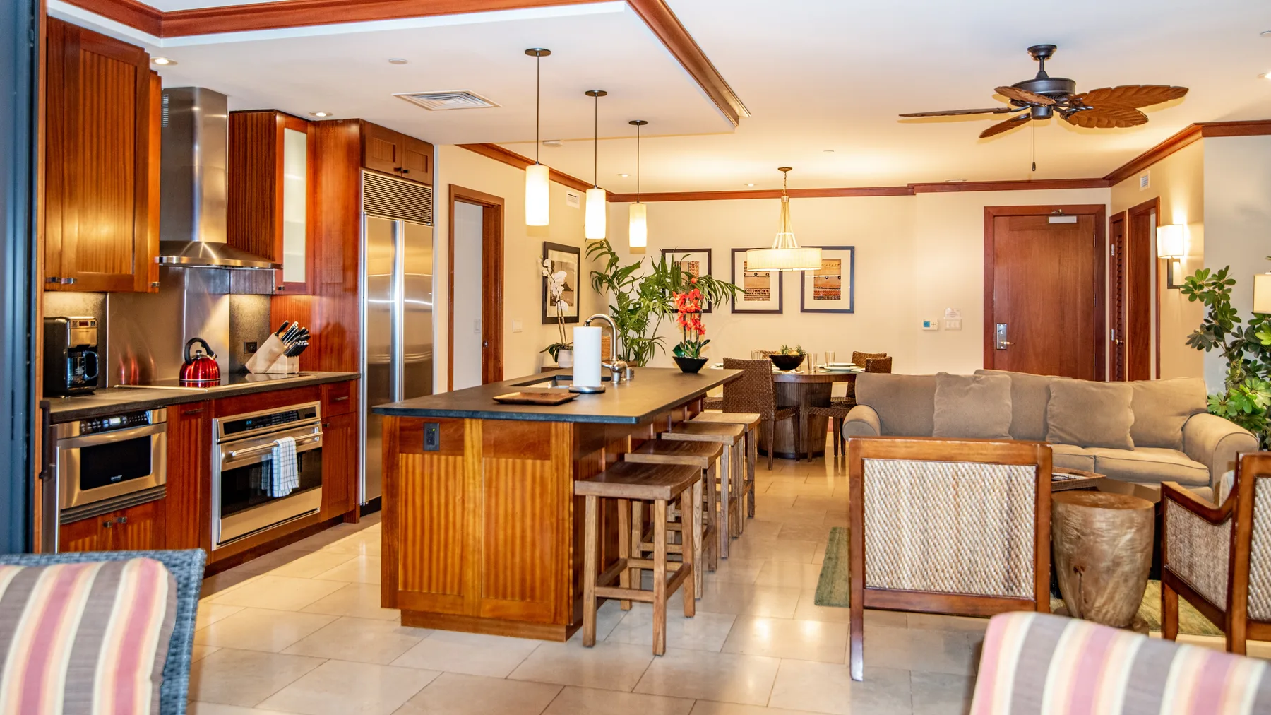 Una cocina abierta y sala de estar con una isla central y asientos.