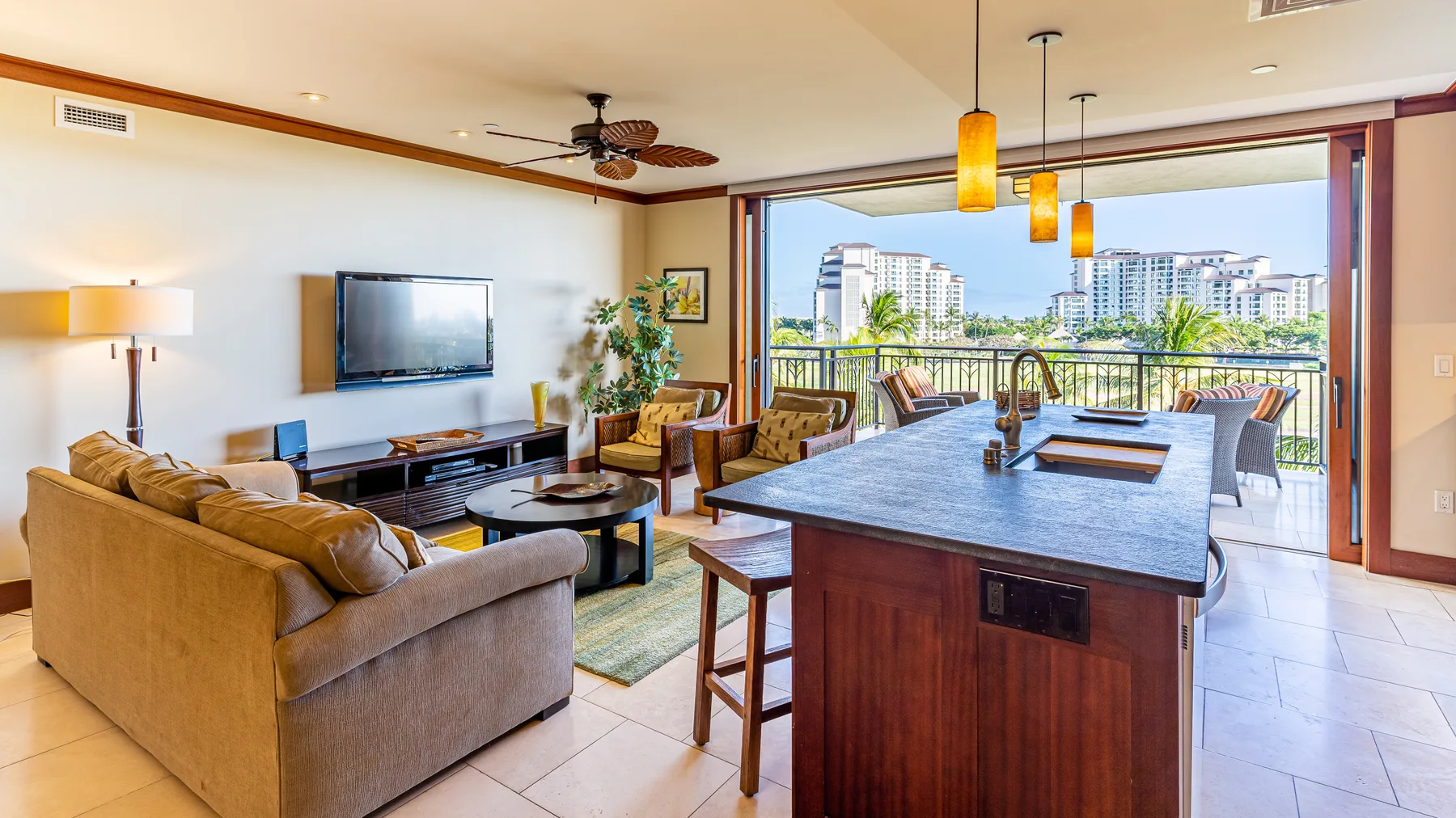 Una sala de estar se abre a una cocina con una isla grande y ventanas amplias.