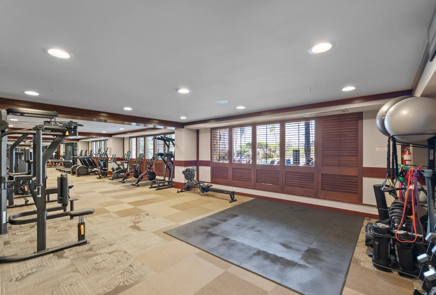 Un gimnasio con máquinas de ejercicio y una amplia zona de entrenamiento.