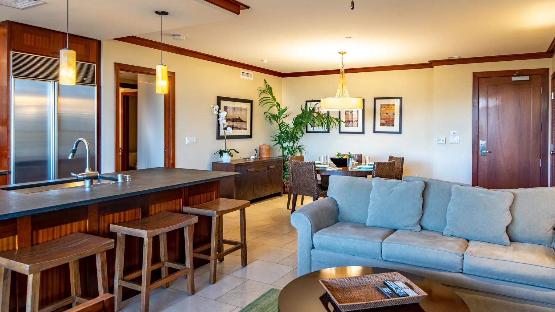 Un espacio abierto de sala y comedor con una barra de cocina y asientos azules.