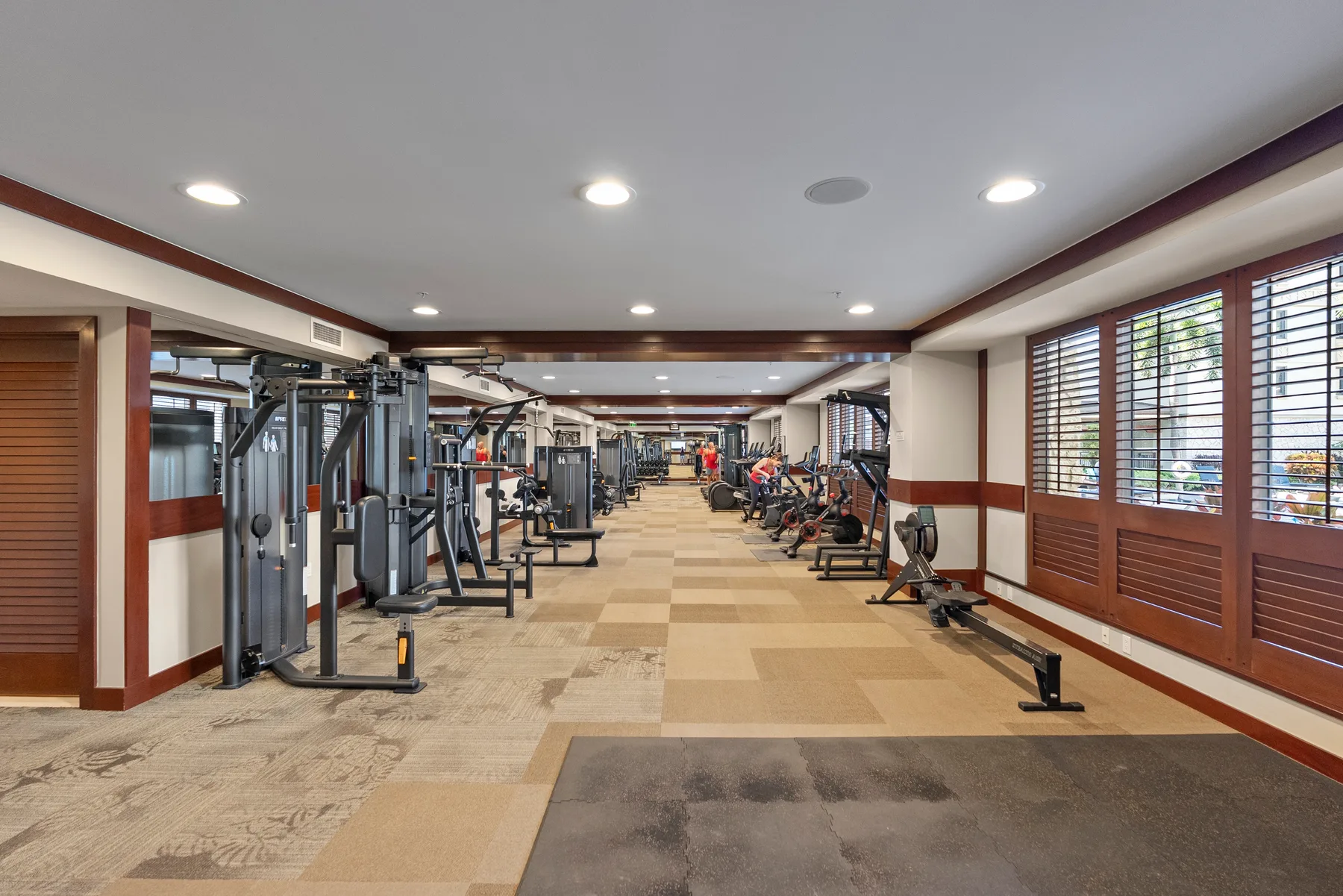 Un gimnasio con máquinas de ejercicio y equipos de entrenamiento distribuidos por la sala.