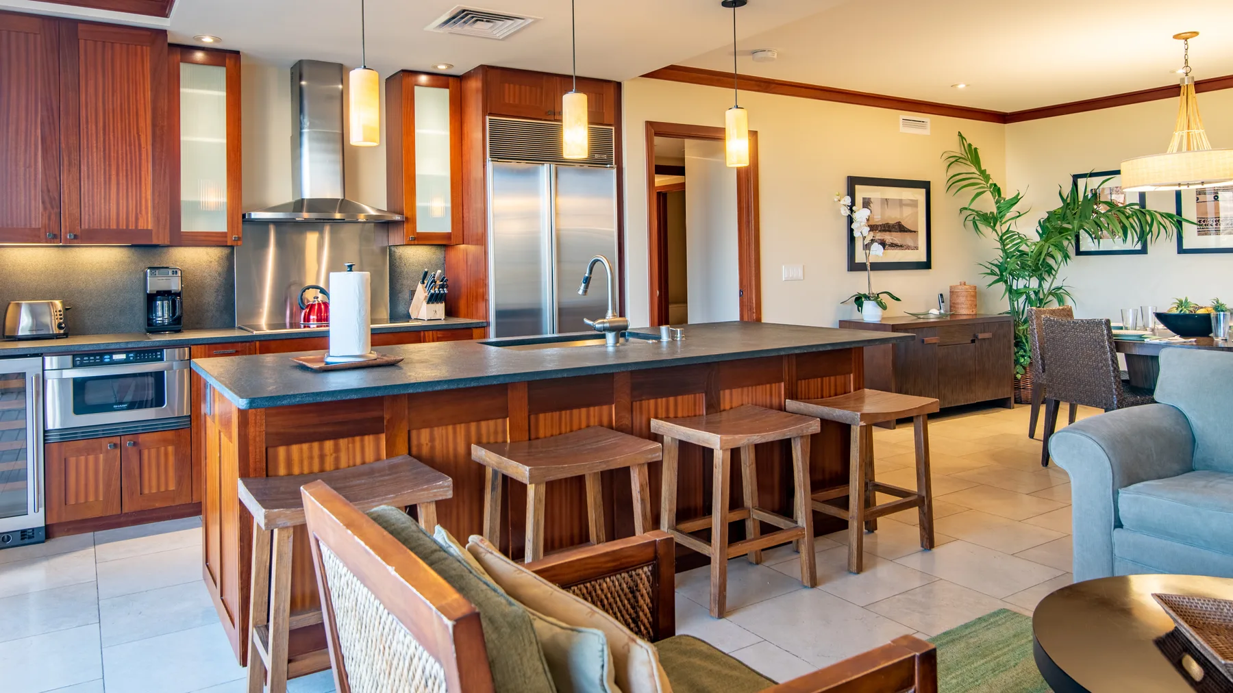 Una cocina luminosa con comedor, una isla larga y asientos de barra.