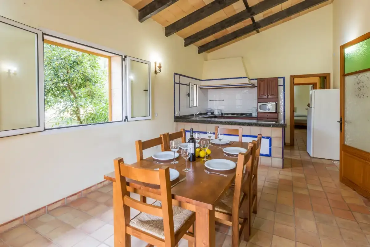 A dining area with a wooden table beside a compact kitchen.