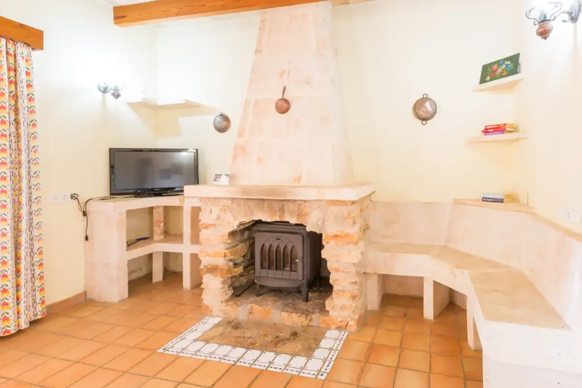 A living room with a fireplace, built-in seating, and a television.