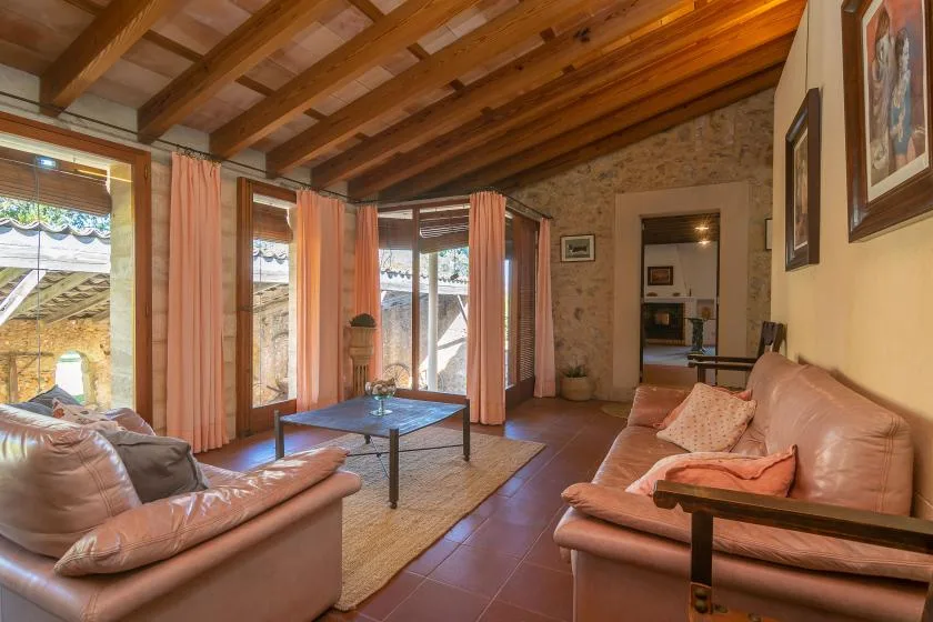 Una sala de estar con asientos de cuero, una mesa de centro y ventanas grandes.