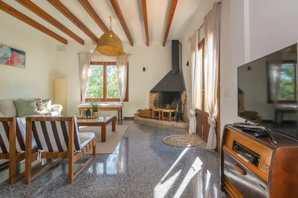 Una sala de estar luminosa con asientos, una chimenea y un televisor.
