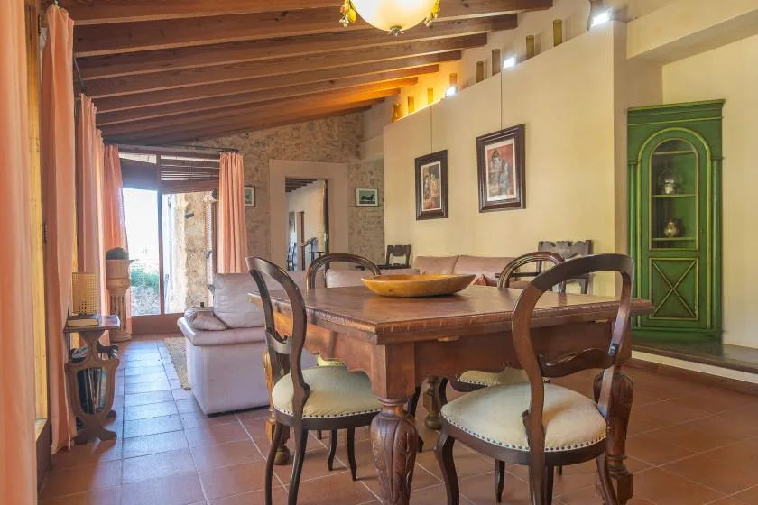 Comedor con una mesa de madera y sillas junto a una zona de estar.