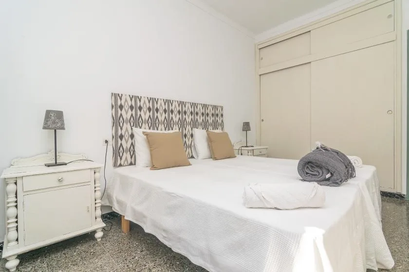 Un dormitorio con una cama grande, un cabecero estampado y mesitas de noche.