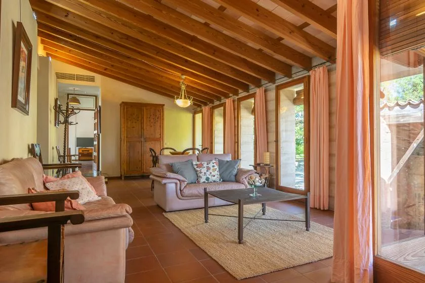 Una sala de estar con asientos, una mesa de centro y grandes ventanas.