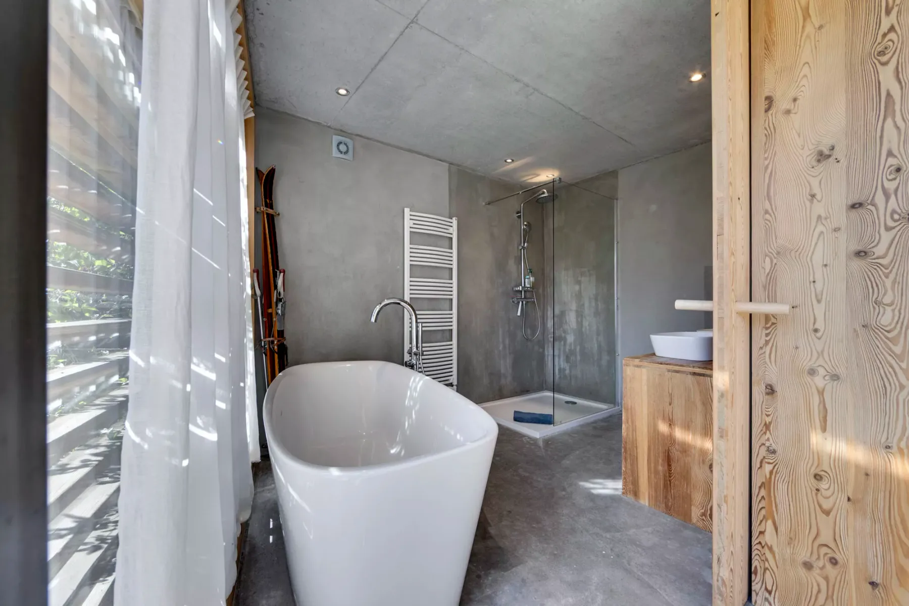Un baño moderno con bañera exenta y ducha de vidrio.