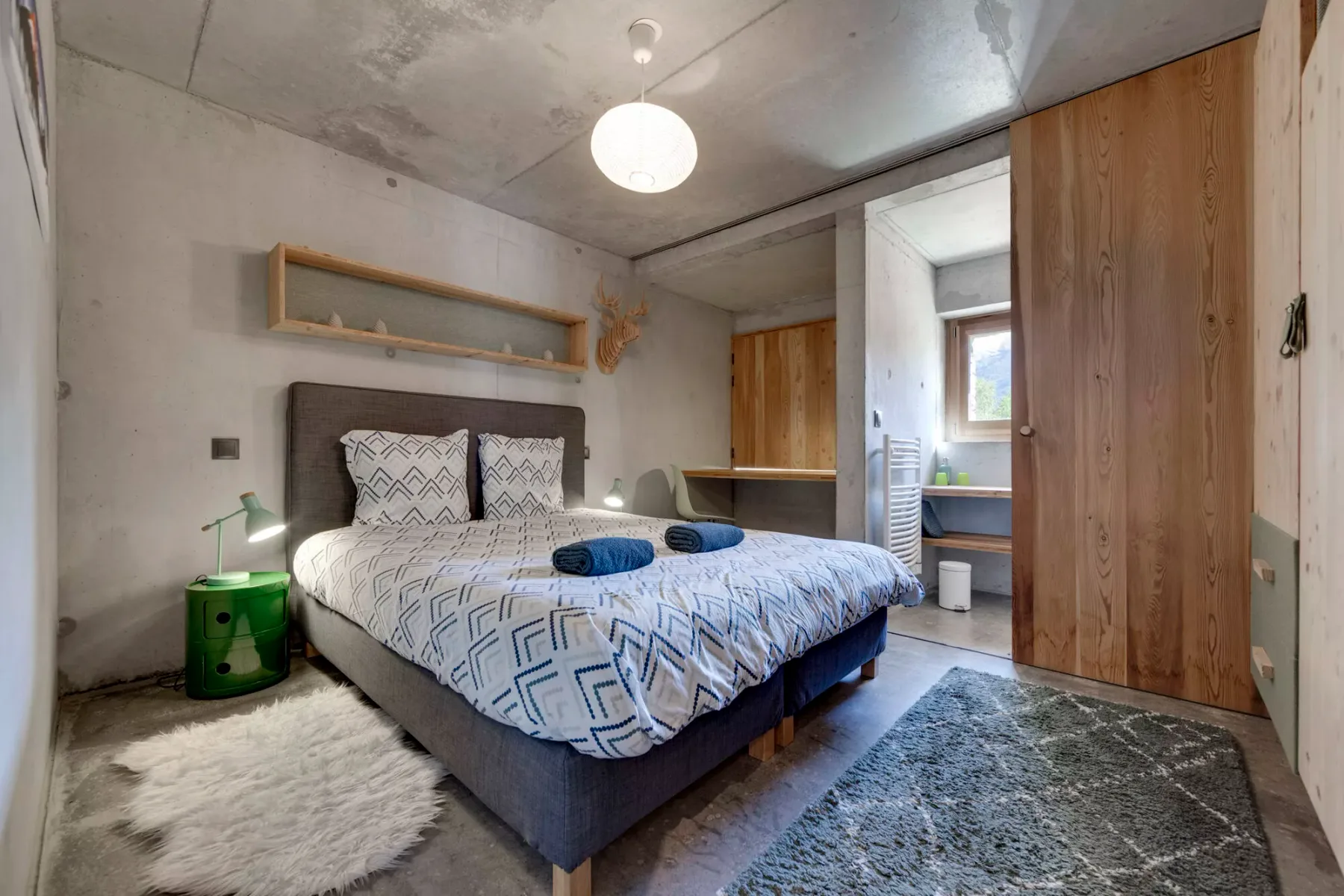 Un dormitorio con una cama, ropa de cama estampada y armarios de madera.