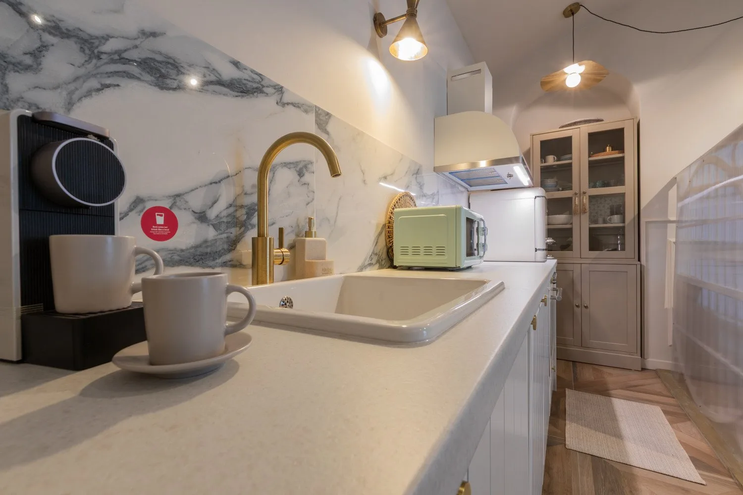 A compact kitchen with a countertop, sink, and small appliances.