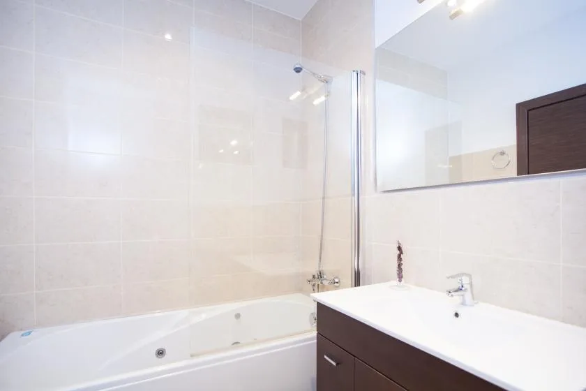 A tiled bathroom with a bathtub and a sink vanity.