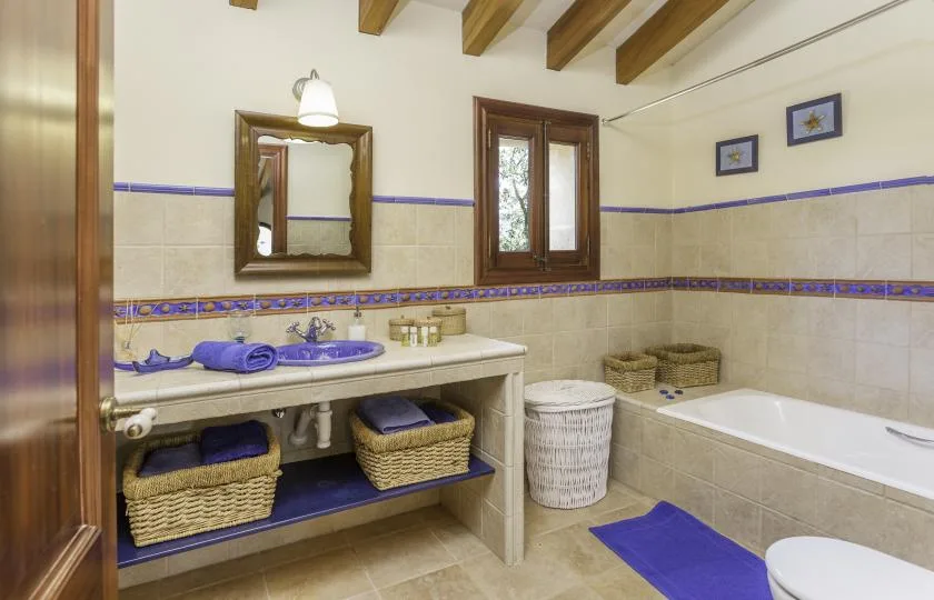 A bathroom with a double sink vanity, bathtub, and blue accents.