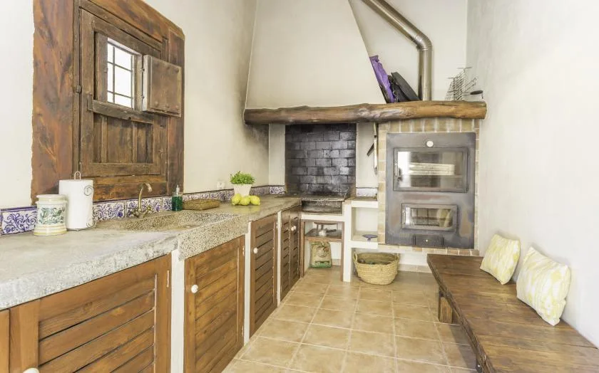 A rustic kitchen with wooden cabinets, a countertop, and a built-in oven.