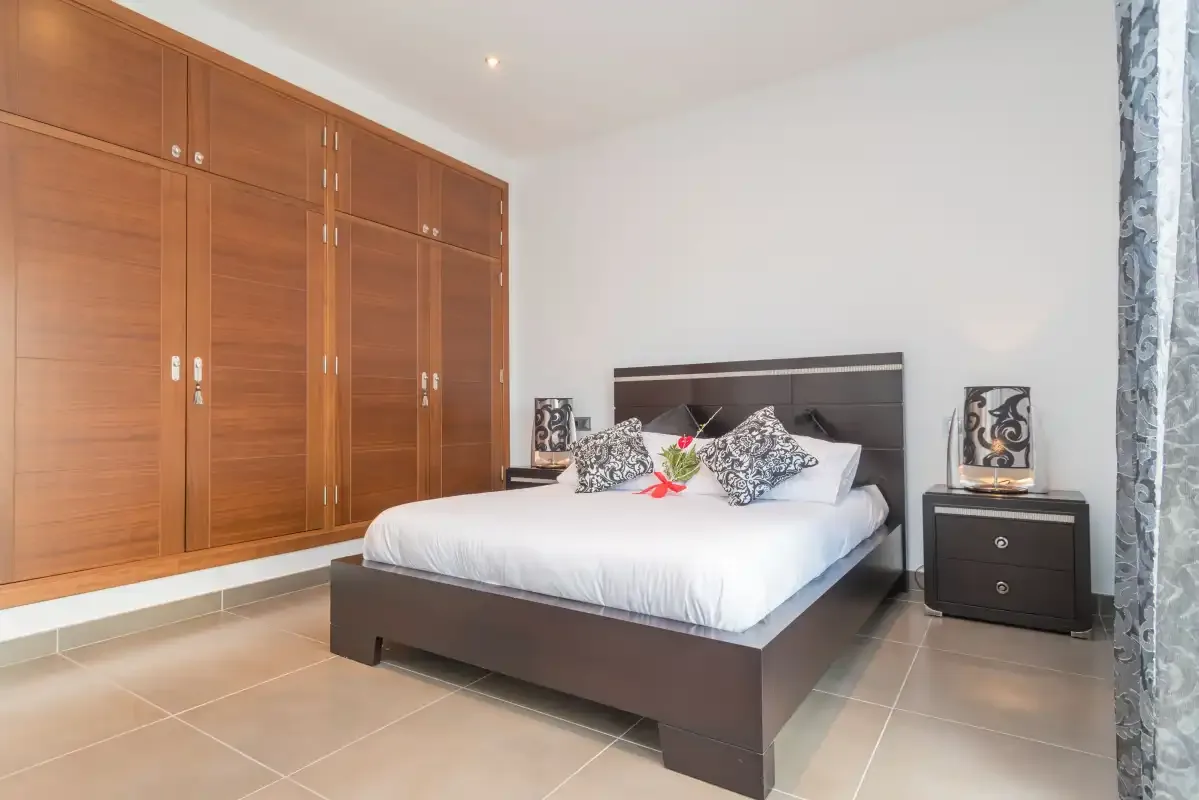 Un dormitorio con una cama, armarios empotrados de madera y mesillas de noche.