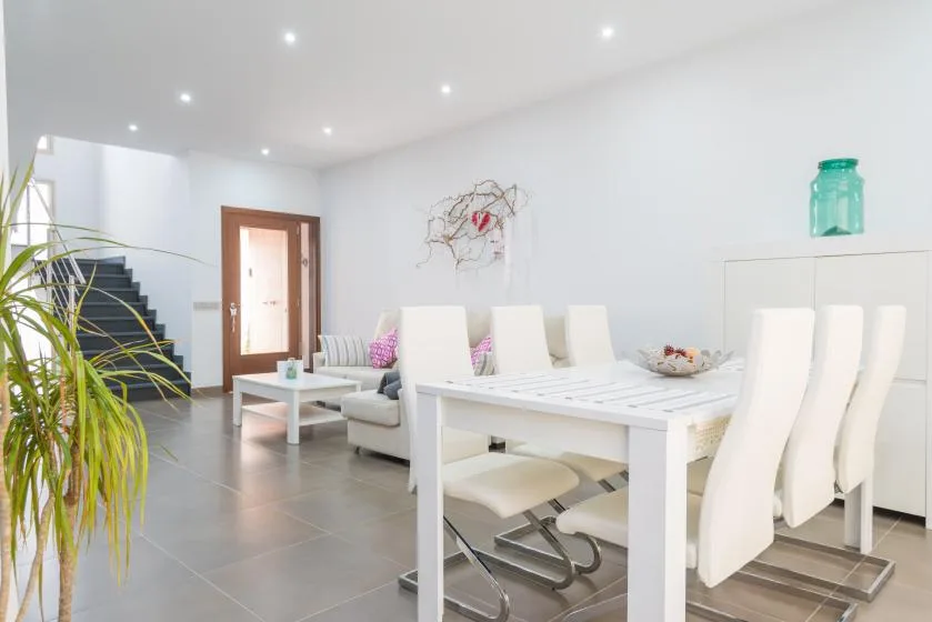 Un comedor luminoso con una mesa blanca y asientos a juego.