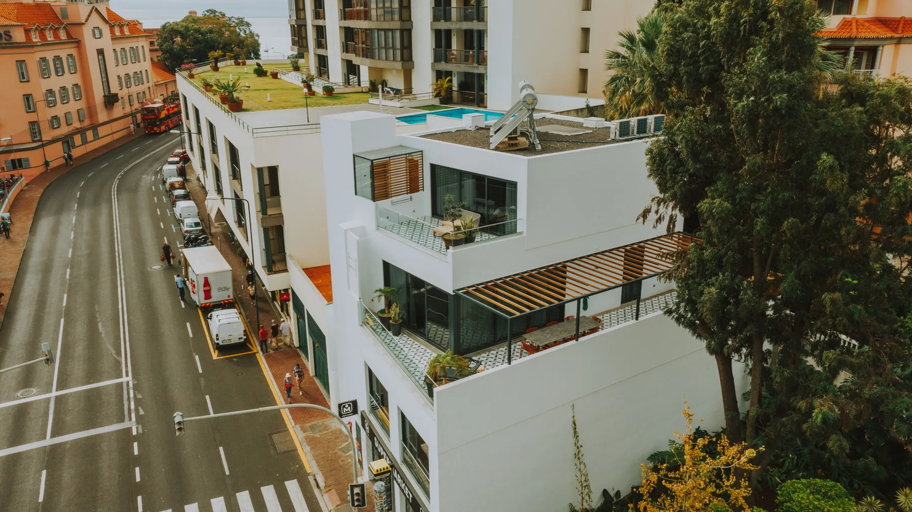 Vista aérea de un edificio blanco moderno junto a una calle curva.