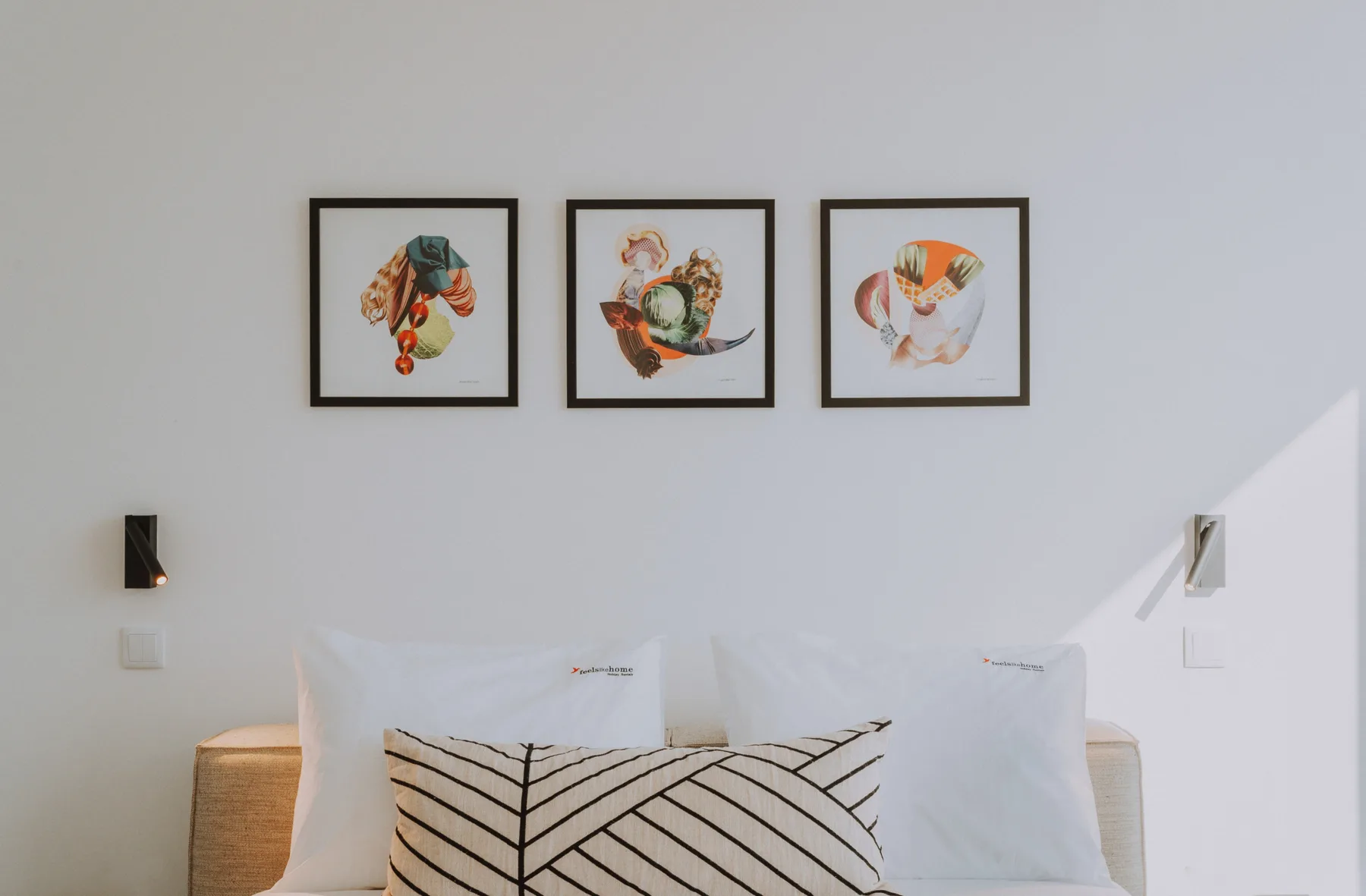 Un dormitorio con una cama, almohadas estampadas y tres cuadros en la pared.