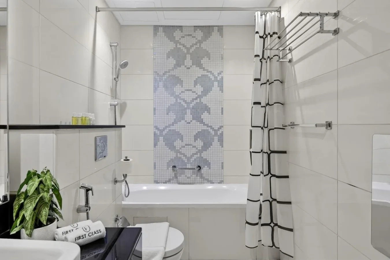 Un baño con azulejos, una bañera y baldosas decorativas en la pared.