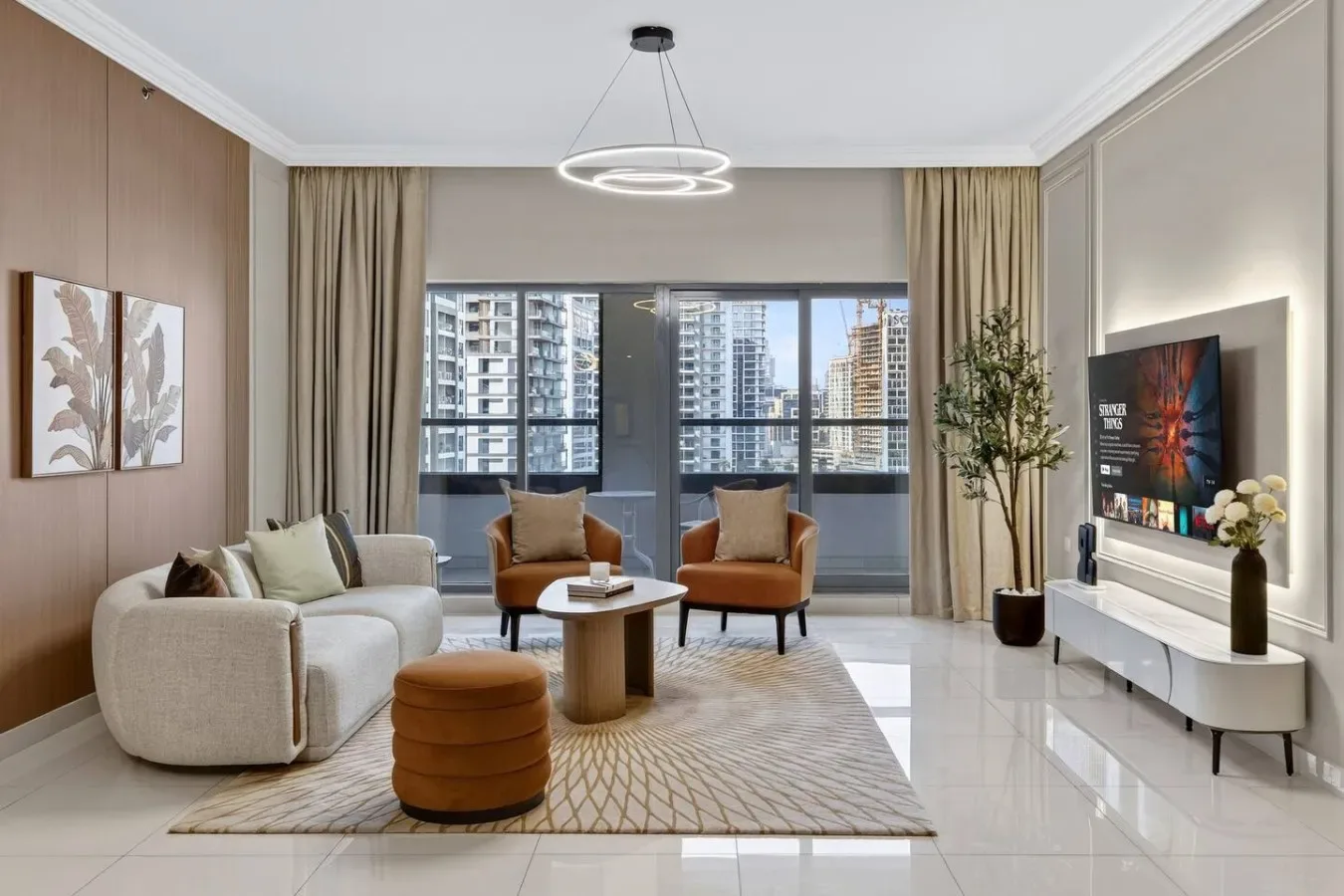 Una sala de estar moderna con asientos alrededor de una mesa de centro y una ventana grande.
